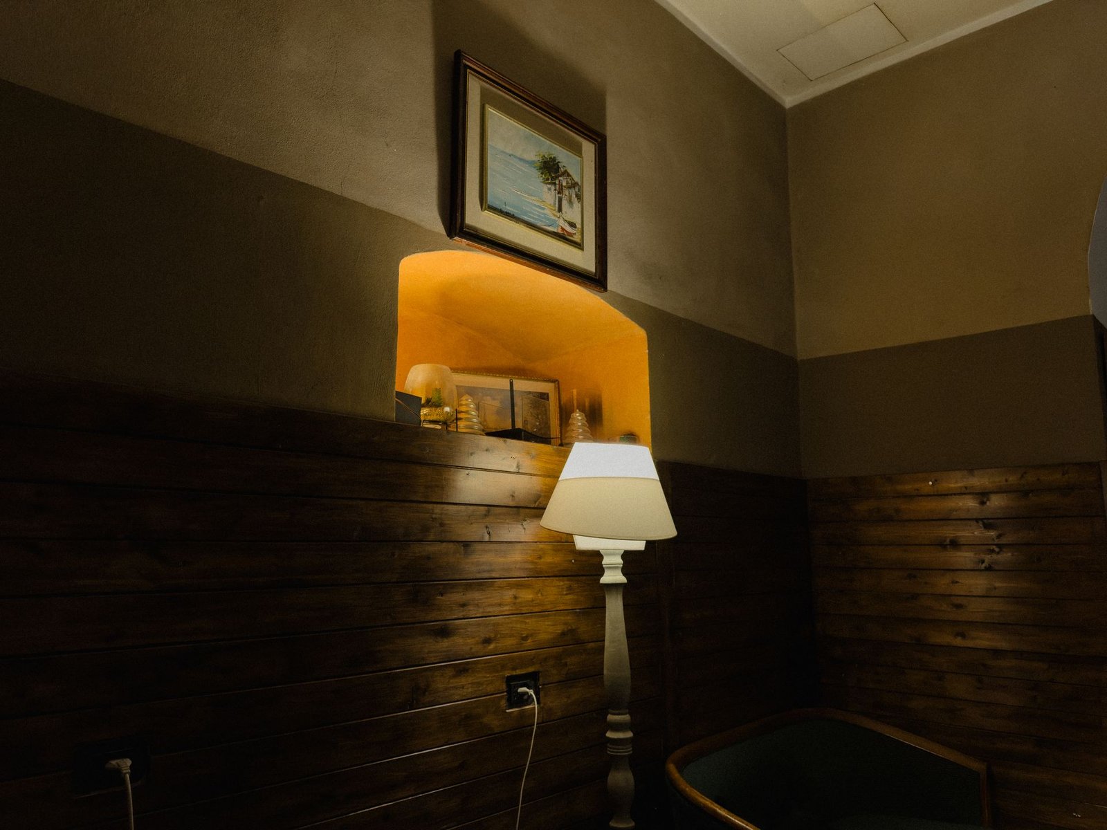 Angolo caldo del Chillout Zone con boiserie in legno, nicchia illuminata e lampada da terra, lounge bar a Imperia