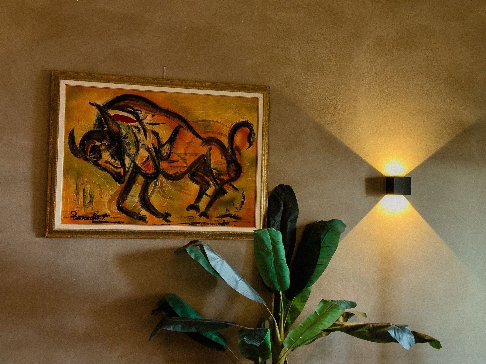 Quadro d'arte e luce d'atmosfera con pianta tropicale nel Chillout Zone, aperitivo bar a Imperia